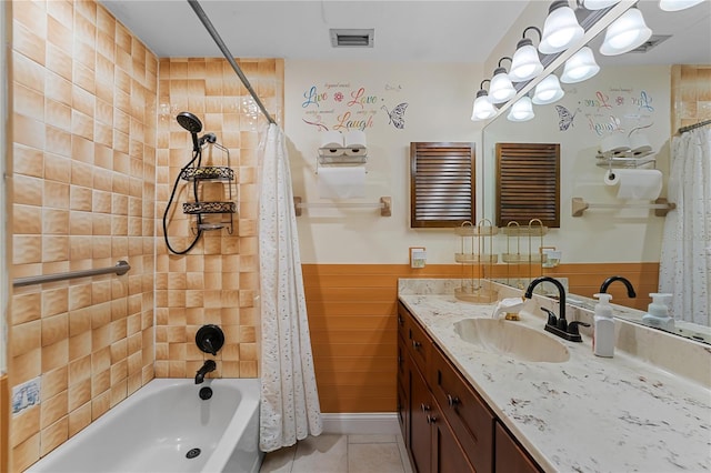 bathroom featuring tile patterned flooring, visible vents, a wainscoted wall, shower / bath combo with shower curtain, and vanity