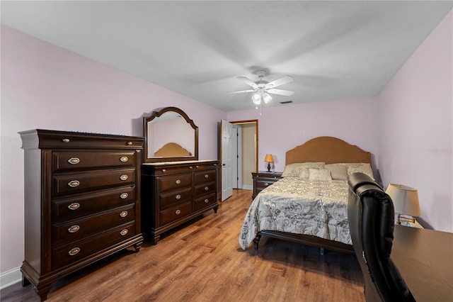 bedroom featuring visible vents, baseboards, light wood-style floors, and a ceiling fan