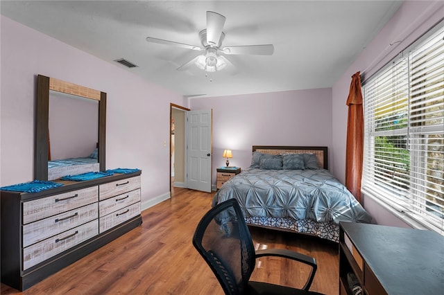 bedroom with visible vents, baseboards, light wood-style floors, and a ceiling fan