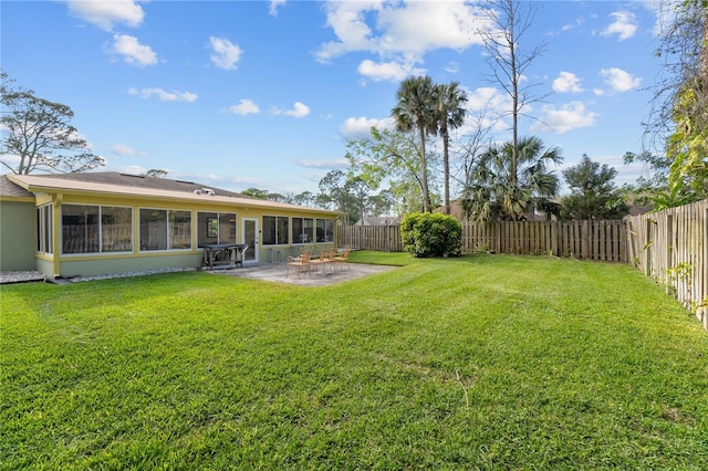 view of yard featuring a patio area, a fenced backyard, and a sunroom