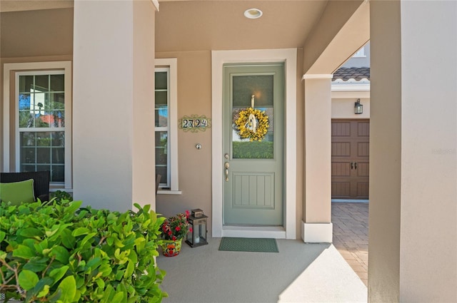 doorway to property featuring a tiled roof and stucco siding