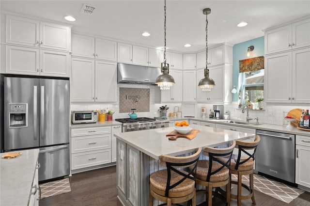 kitchen with visible vents, under cabinet range hood, a sink, stainless steel appliances, and white cabinets