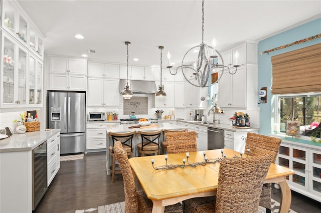 kitchen featuring wine cooler, under cabinet range hood, light countertops, appliances with stainless steel finishes, and a sink