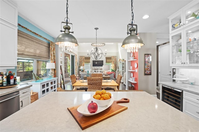 kitchen featuring pendant lighting, stainless steel dishwasher, wine cooler, white cabinets, and glass insert cabinets