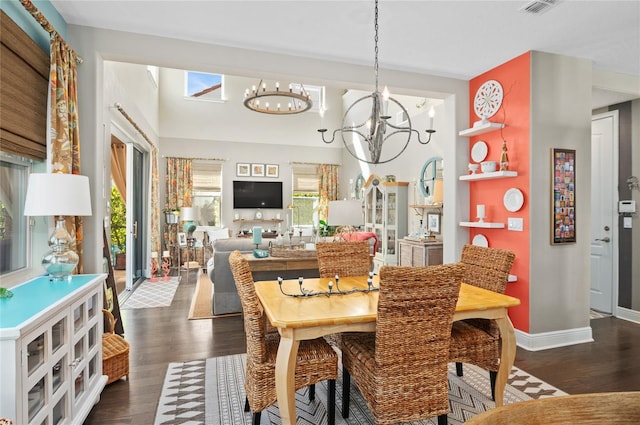 dining space featuring dark wood-style floors, visible vents, baseboards, and an inviting chandelier