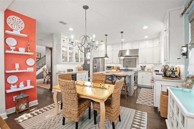 dining room featuring visible vents, dark wood-style floors, recessed lighting, an inviting chandelier, and stairs