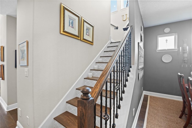 staircase with baseboards and wood finished floors