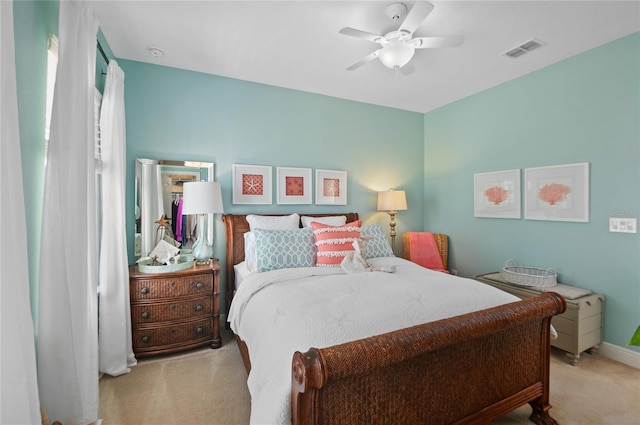 carpeted bedroom featuring visible vents, baseboards, and ceiling fan