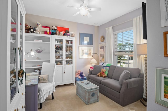 living area featuring light carpet and ceiling fan