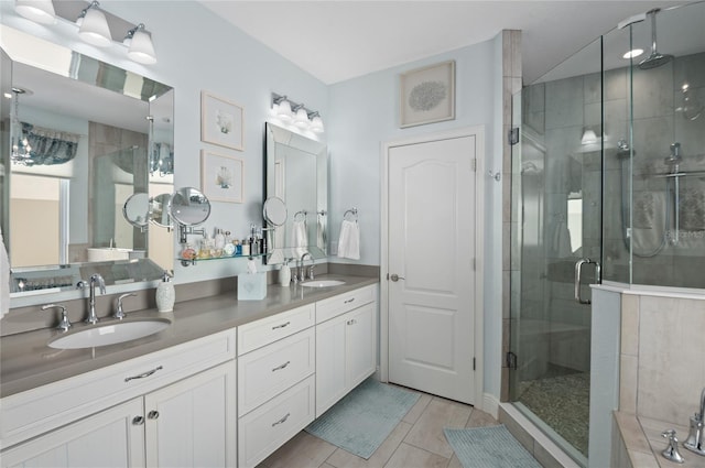 full bathroom with tile patterned flooring, a stall shower, double vanity, and a sink