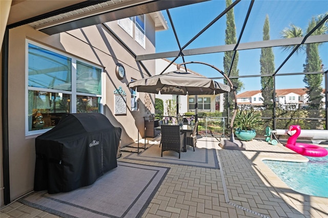 view of patio featuring glass enclosure and grilling area