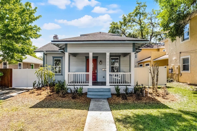 view of front of property featuring fence and covered porch