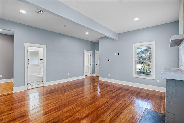 unfurnished living room with recessed lighting, visible vents, wood-type flooring, and baseboards