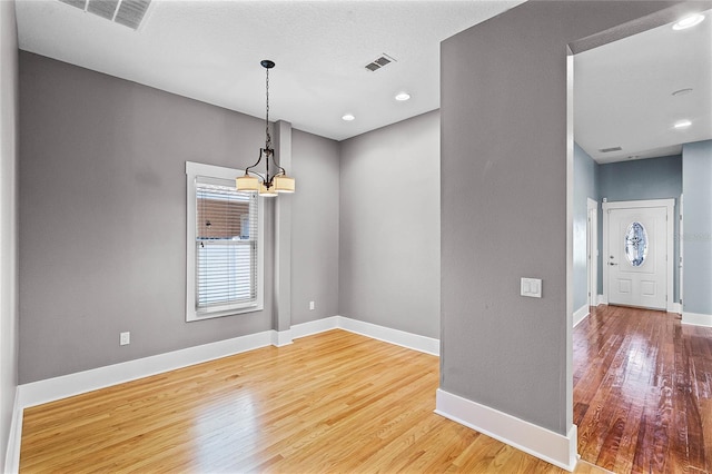 spare room with recessed lighting, visible vents, baseboards, and wood finished floors