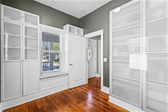 interior space featuring dark wood finished floors and a textured ceiling