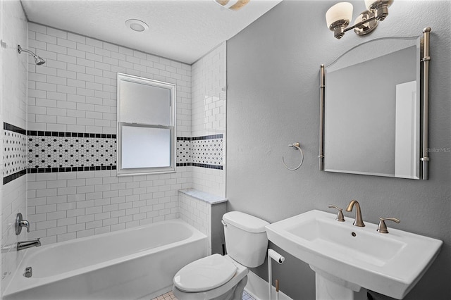 full bathroom with toilet, a sink, a textured ceiling, shower / washtub combination, and a textured wall