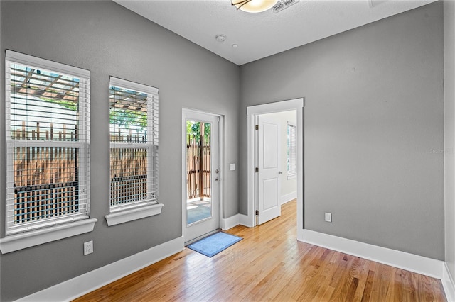 interior space featuring visible vents, baseboards, and wood finished floors