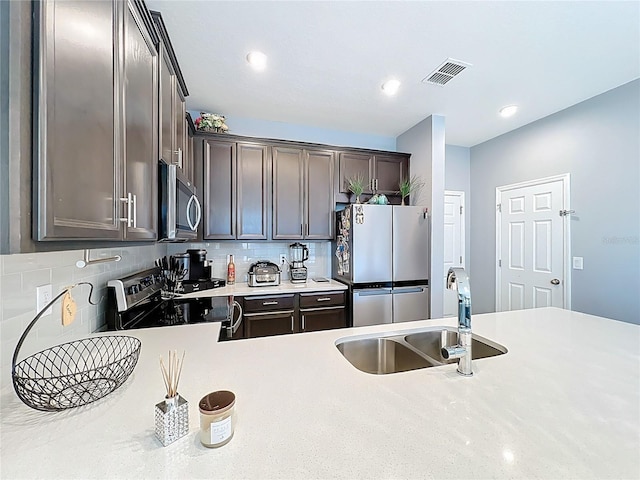 kitchen featuring stainless steel appliances, light countertops, visible vents, backsplash, and a sink