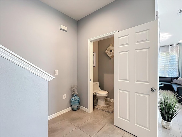 bathroom with toilet, visible vents, baseboards, and tile patterned floors