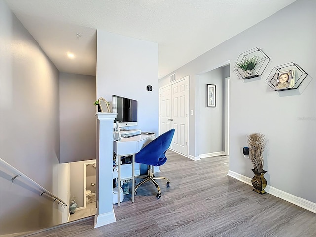 office with visible vents, baseboards, and wood finished floors