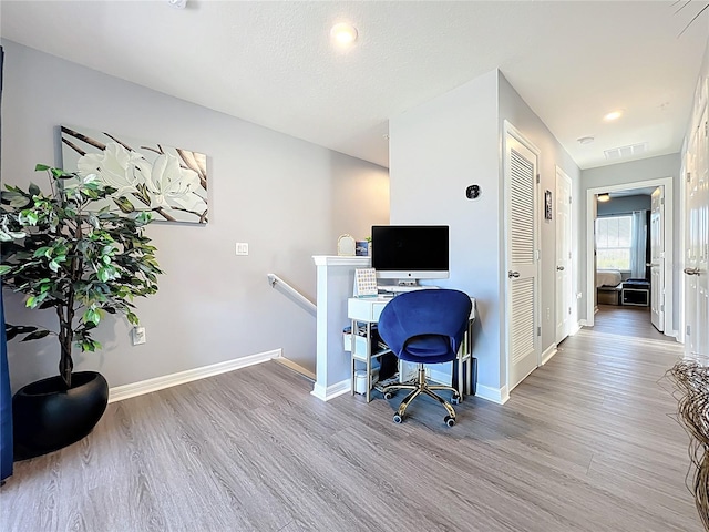 office area featuring wood finished floors, visible vents, and baseboards