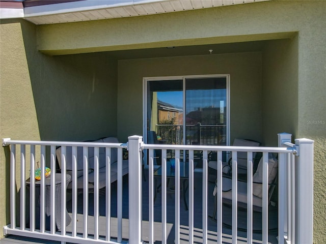 doorway to property featuring central AC, a balcony, and stucco siding