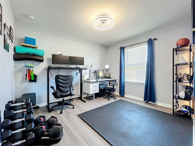 home office featuring a textured ceiling, wood finished floors, and baseboards