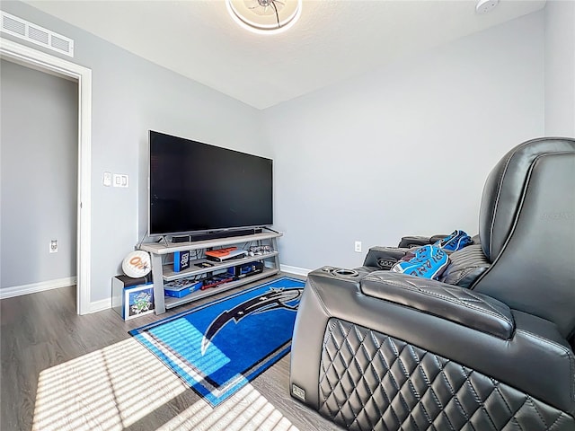 living area featuring baseboards, visible vents, and wood finished floors