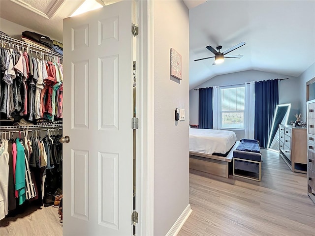 bedroom with lofted ceiling, light wood-style floors, and a closet