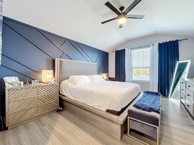 bedroom featuring ceiling fan, light wood-style flooring, and vaulted ceiling