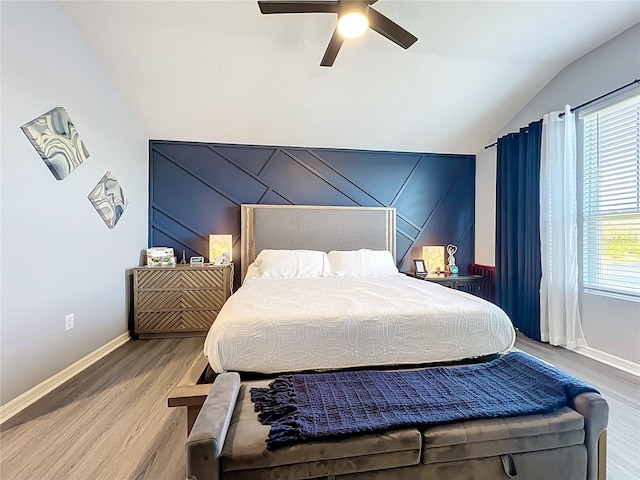 bedroom with lofted ceiling, wood finished floors, a ceiling fan, and baseboards