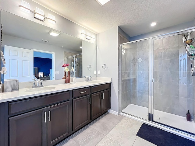 full bathroom with double vanity, a stall shower, a sink, and ensuite bathroom