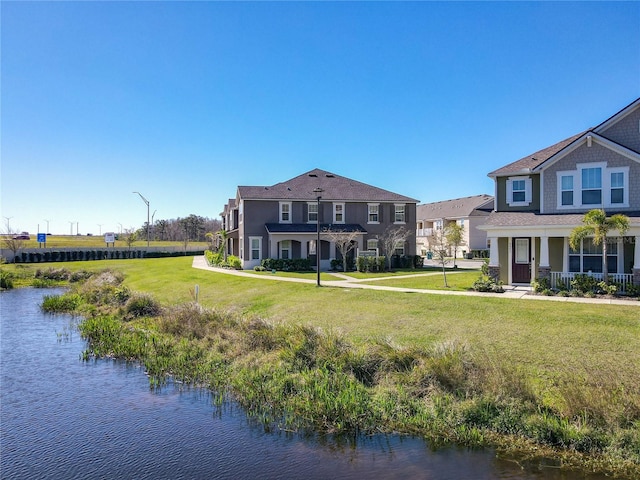 exterior space featuring a water view, a lawn, and stucco siding