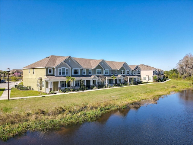 view of front of house featuring a residential view, a water view, and a front yard