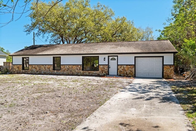 single story home featuring a garage, stone siding, and driveway