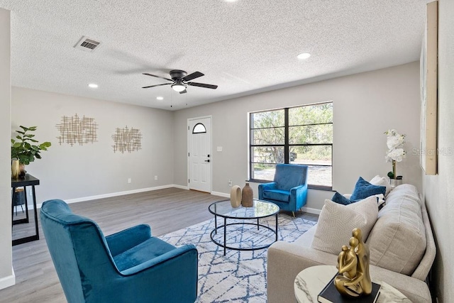 living area with a ceiling fan, wood finished floors, visible vents, baseboards, and recessed lighting