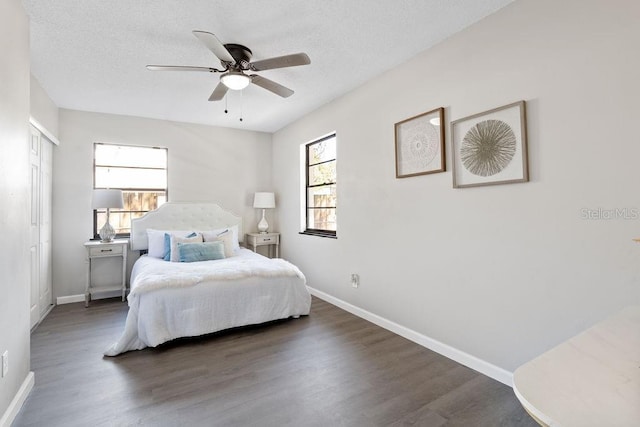 bedroom with a textured ceiling, wood finished floors, a ceiling fan, and baseboards