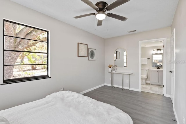 bedroom featuring visible vents, ceiling fan, connected bathroom, wood finished floors, and baseboards