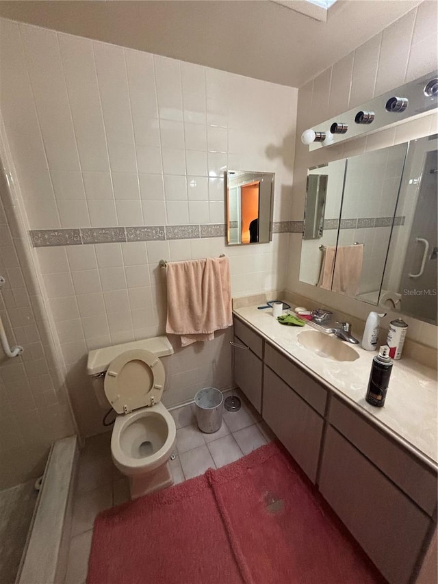 full bathroom featuring a skylight, toilet, tile patterned flooring, vanity, and tile walls