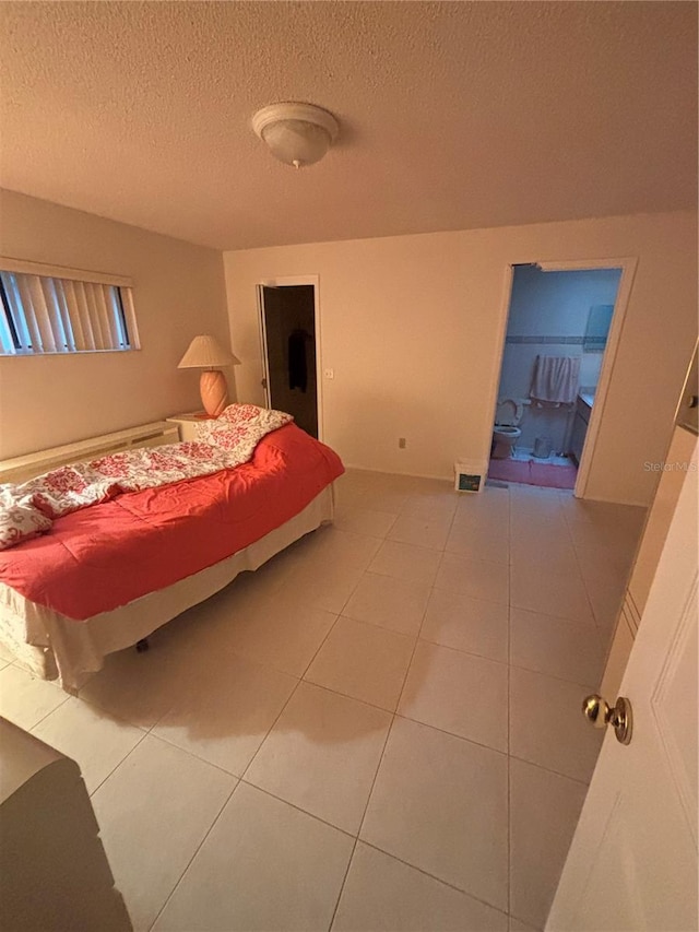 bedroom featuring a textured ceiling, visible vents, and tile patterned floors