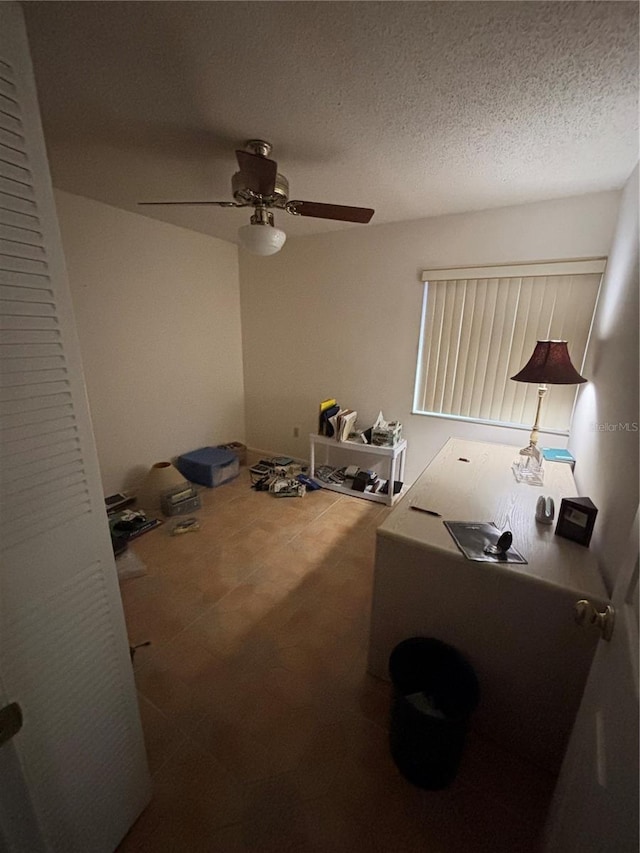 bedroom with a ceiling fan and a textured ceiling