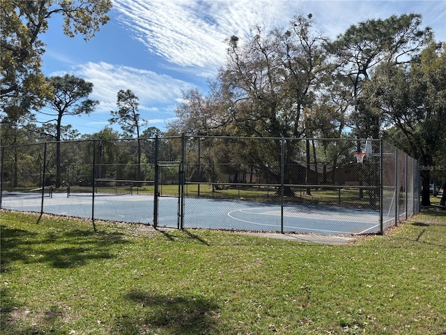 view of basketball court featuring community basketball court, fence, and a lawn