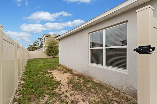 view of home's exterior with a yard, a fenced backyard, and stucco siding