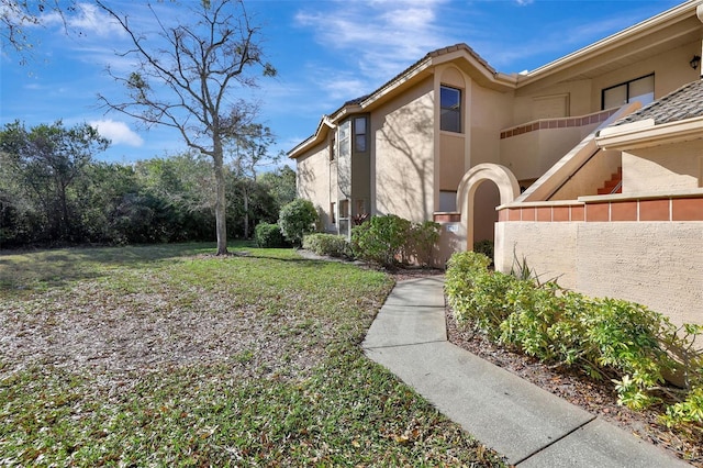 view of home's exterior featuring stucco siding and a lawn