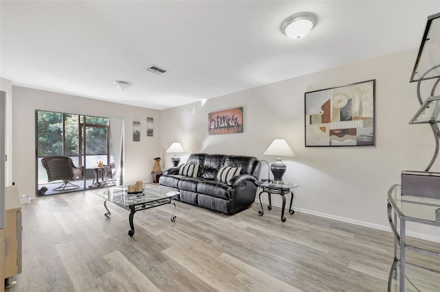 living area with visible vents, baseboards, and wood finished floors