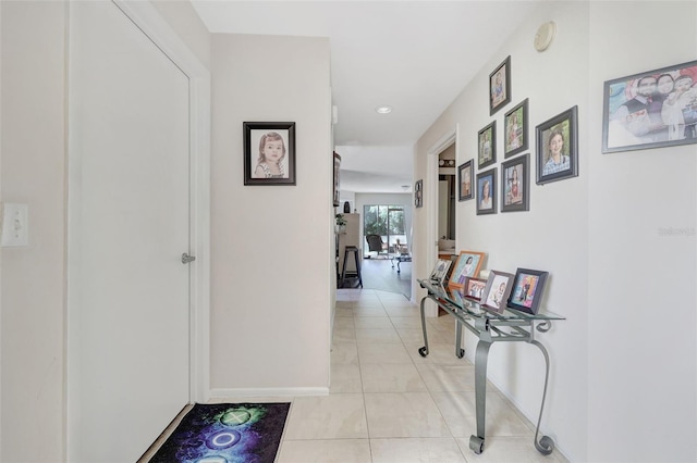 hallway with light tile patterned floors and baseboards