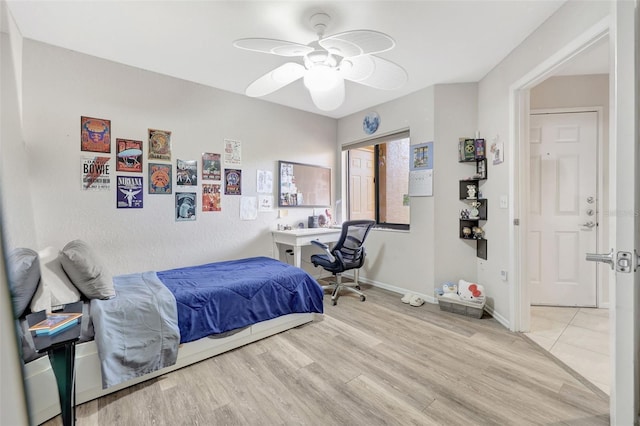 bedroom with ceiling fan, baseboards, and wood finished floors