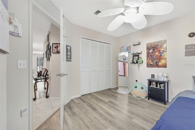 bedroom featuring baseboards, visible vents, ceiling fan, a closet, and light wood-type flooring