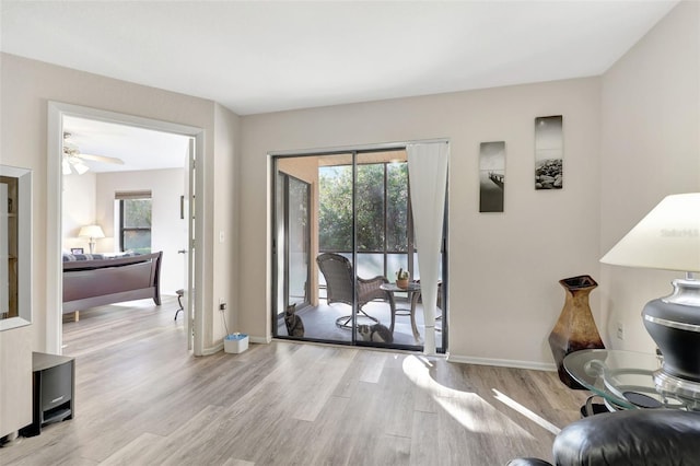 doorway featuring baseboards and light wood finished floors