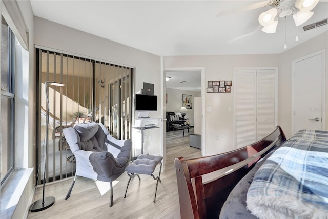 bedroom with a closet, visible vents, ceiling fan, and wood finished floors